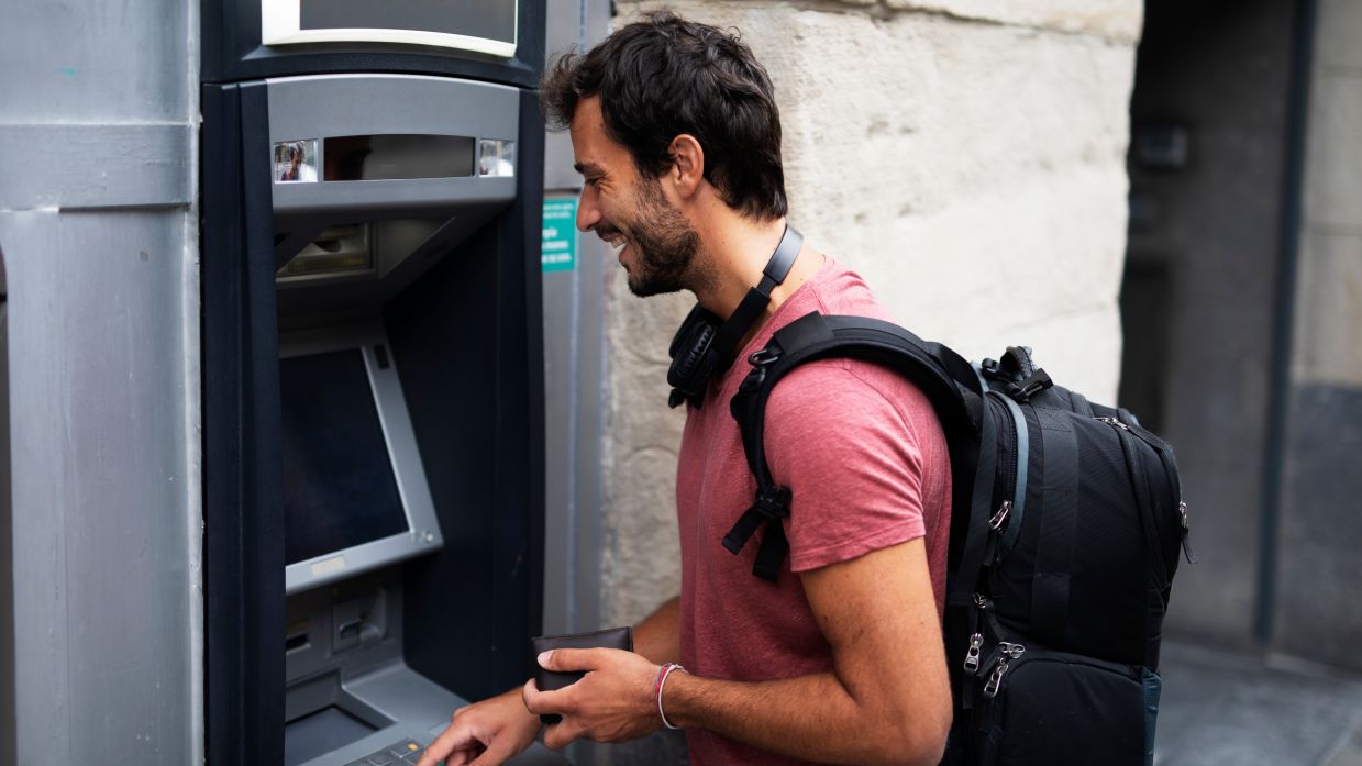 Young,Man,Withdrawing,Money,From,Credit,Card.,Man,Typing,Pin